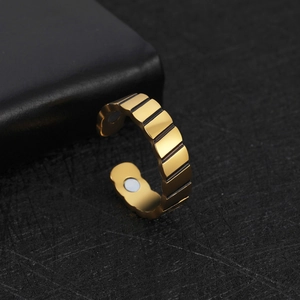 Vue macro d'une bague en acier doré avec rayures verticales industrielles et deux aimants