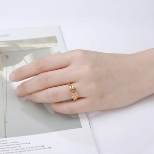 Detailopname van een gouden opengewerkte ring met maan- en Keltische knoop om de vinger