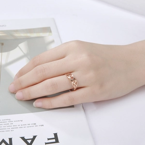 Detail van een roségouden holle ring met maan en Keltische knoop aan de vinger