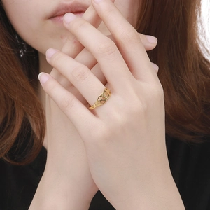 Detail van vergulde XOX opengewerkte ring aan vinger met vakmanschap en mooie glans