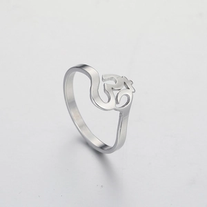 Macro shot of silver titanium steel ring featuring an intricate hollowed Om yoga symbol