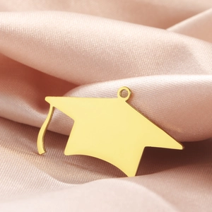 Polished 18K gold stainless steel graduation cap pendant on elegant pink silk fabric