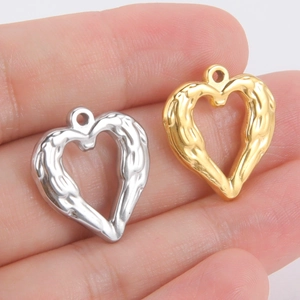 Détail de pendentifs en forme de cœur dorés et argentés avec texture pour bijoux DIY