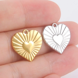 Détail de pendentifs en forme de cœur avec texture rayonnante et incrustation de cœur central