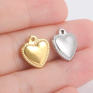 Détail macro de pendentifs cœur en or et argent avec bordure perlée pour création de bijoux