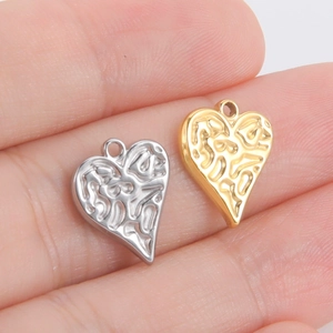 Vue macro de pendentifs cœur en acier dans la main montrant la taille et la texture
