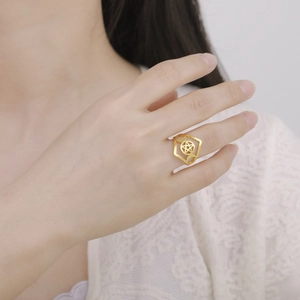 Detail of a gold pentagram ring with moon design worn on a model's finger