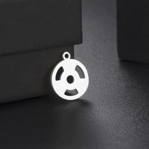 Macro detail of silver stainless steel dumbbell plate pendant with cutout design