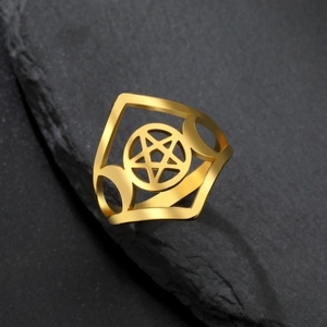 Macro view of gold triple moon and pentagram cutout detail on a stainless steel ring
