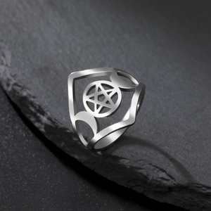 Silver stainless steel pentagram ring with crescent moons on a textured slate background