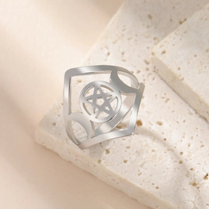 Macro shot of silver stainless steel ring with hollow pentagram and moon side patterns
