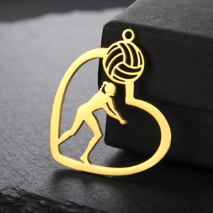 Macro view of gold-plated heart pendant featuring a volleyball player silhouette design