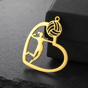 Detailed close-up of a gold-plated heart-shaped volleyball pendant on a stone base
