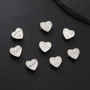 Pendentifs cœurs en argent avec gravures pour bijoux DIY sur surface en pierre sombre
