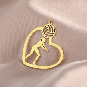 Polished 18K gold heart pendant with volleyball player silhouette on silk background