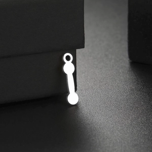 Close-up of polished stainless steel dumbbell pendant with smooth metallic texture