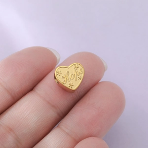 Détail d'un pendentif coeur doré avec gravure Hope et motifs floraux pour bijoux DIY