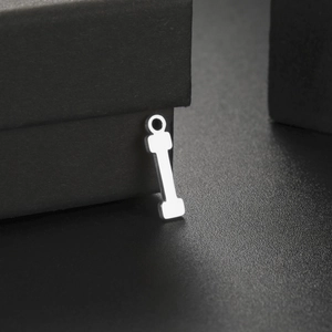 Polished silver stainless steel dumbbell pendant on luxury black jewelry box display