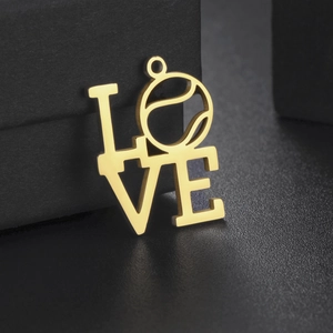 Dettaglio di un ciondolo LOVE dorato con pallina da tennis su espositore nero