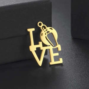 Dettaglio ravvicinato del ciondolo LOVE dorato con design a fischietto e finitura lucida