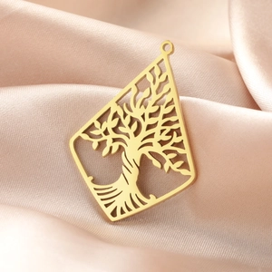 Close-up of golden 18K hollow tree of life pendant on elegant champagne silk fabric