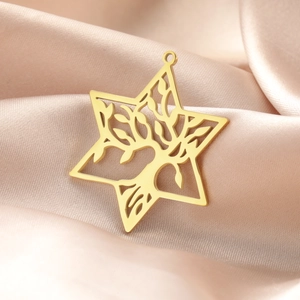 Macro shot of gold Tree of Life pendant with Star of David outline on silk fabric