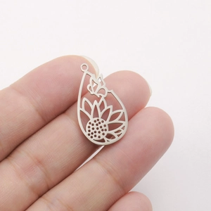 Detail of silver drop-shaped hollow pendant with sunflower and butterfly for DIY jewelry