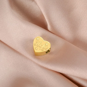 Détail du pendentif cœur doré avec texte Hope gravé et motifs floraux élégants