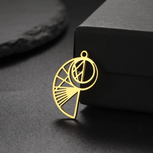 Macro d'un pendentif escargot de mer doré ajouré posé contre un écrin à bijoux noir