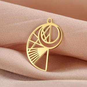 Pendentif géométrique ajouré en métal doré présenté sur un tissu en soie élégant