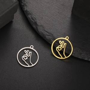 Detailed macro view of gold and silver OK gesture hollow round pendants for DIY jewelry