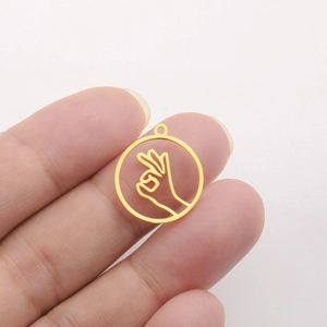 Macro view of 18K gold plated heart and OK gesture hollow round pendant on hand