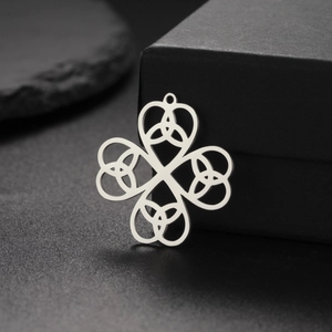 Polished stainless steel four-leaf clover pendant with Celtic knot cutouts on a gift box