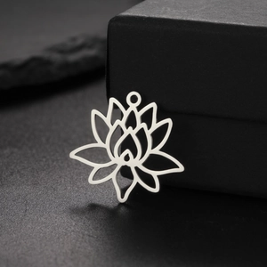 Hollow lotus pendant in stainless steel displayed on a black stone and gift box background
