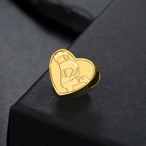 Gros plan d'un pendentif cœur doré pour bijoux DIY avec motif gravé au laser sur fond noir