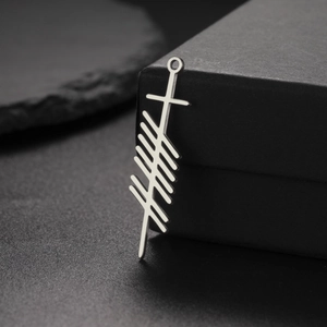Polished stainless steel Ogham rune pendant with Celtic sword shape on dark stone background