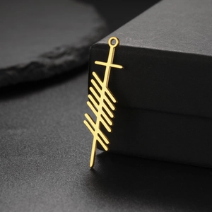 Detailed macro shot of a golden Ogham symbol pendant on a minimalist black gift box