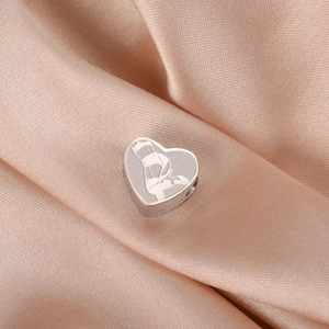 Vue macro d'un pendentif en forme de cœur en acier inoxydable avec silhouette laser