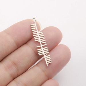 Close-up of a long stainless steel pendant featuring ancient Ogham Celtic engraving