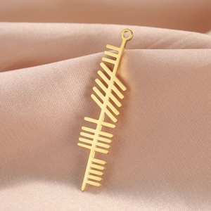 Polished gold stainless steel Celtic tree Ogham bar pendant on satin background