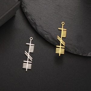 Ogham style stainless steel bar pendants in gold and silver on black stone base