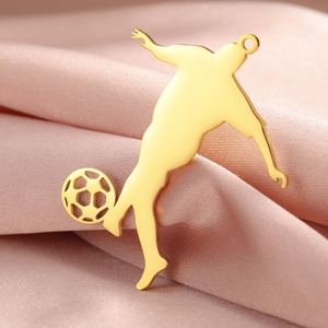Macro shot of 18K gold-plated soccer player silhouette pendant on pink silk fabric