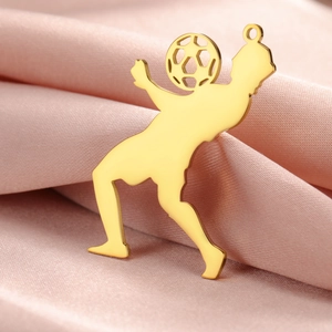 Vue macro d'un pendentif silhouette de footballeur doré sur un tissu en soie rose