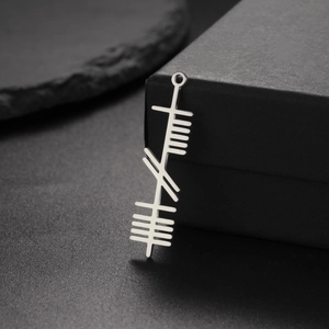 Macro shot of silver stainless steel Celtic Ogham pendant on a black jewelry box