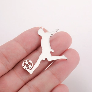 Polished stainless steel soccer player silhouette pendant held for scale and detail