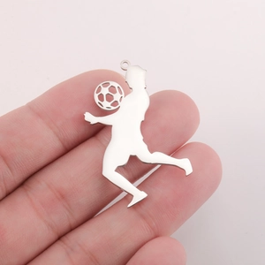Gros plan détaillé montrant un pendentif silhouette de footballeur en argent à la main