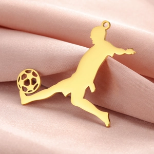 Detailed view of golden stainless steel soccer player pendant on pink silk background