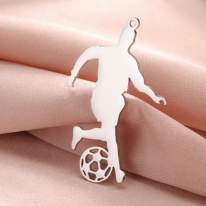 Polished silver soccer player silhouette pendant on pink satin fabric background
