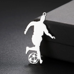Macro detail of polished silver soccer player pendant with cutout football design
