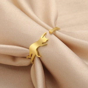 Detailed view of an adjustable gold cat silhouette ring on elegant champagne satin fabric